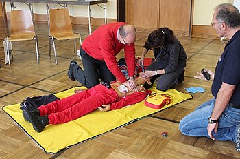 Mitarbeiter des Rathauses �ben den Umgang mit dem Defibrillator. Foto: StVw