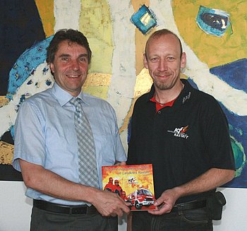 Kreisjugendfeuerwehrwart Frank Rieger �berreicht Oberb�rgermeister Florus das Jubil�umsbuch des Kreisfeuerwehrverbandes Rastatt